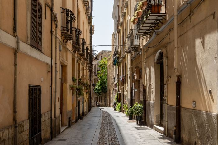 Quiet old-town lane in Sardinia with balconies and plants
