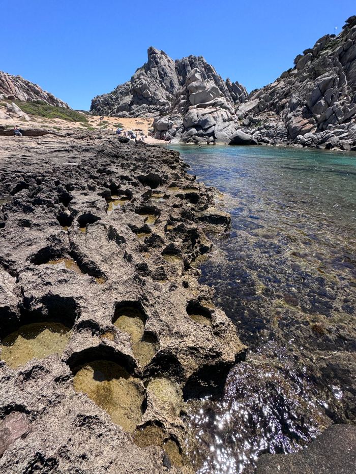 Clear water in a Sardinian cove between weathered rocks